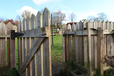 a wooden fence with a gate in a field at The Biscuit Box Ideal For Couples Or Families in Low Hesket