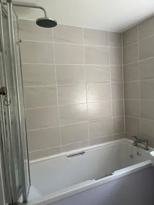 a bathroom with a bath tub and a sink at Lower Mill Apartment in Newmilns