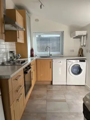 a kitchen with a sink and a washing machine at Lower Mill Apartment in Newmilns