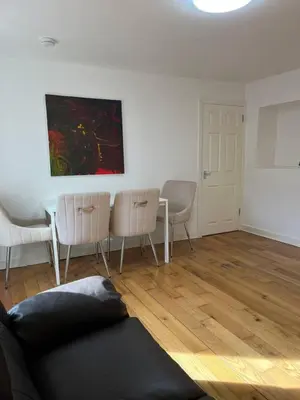 a living room with a couch and a table and chairs at Lower Mill Apartment in Newmilns