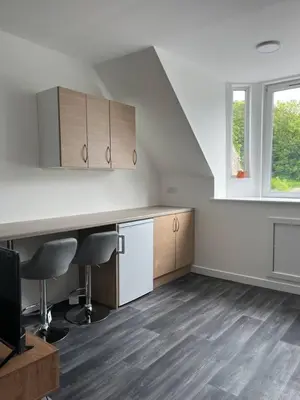 an empty room with a kitchen with a table and chairs at Upper Mill Apartment in Newmilns