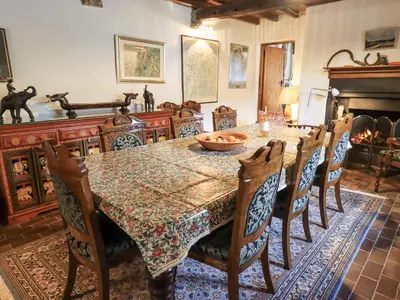 a dining room with a table and chairs and a fireplace at Chapel Cottage in Cleator