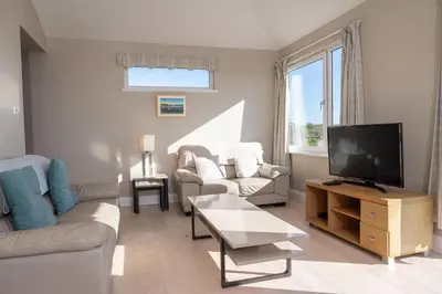 a living room with a couch and a tv at Larroch Farmhouse in Monreith