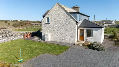 a small stone house with a small yard at Larroch Farmhouse in Monreith