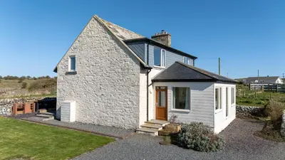 a small white cottage with a door and a yard at Larroch Farmhouse in Monreith