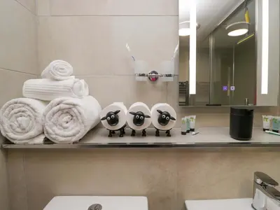 a bathroom with three penguins on a shelf with towels at Yeat Stoup Cottage in Cockermouth