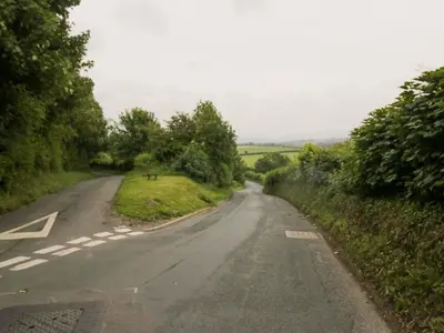 an empty road in the middle of a field at Yeat Stoup Cottage in Cockermouth