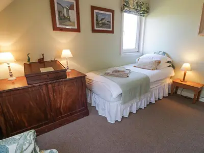 a bedroom with two beds and a dresser and two lamps at Claymoddie in Newton Stewart