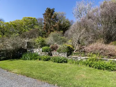 a garden with a stone wall and plants at Claymoddie in Newton Stewart