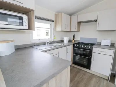 a kitchen with a sink and a stove top oven at Manor House Gold 2 Bedroom 20C in Maryport