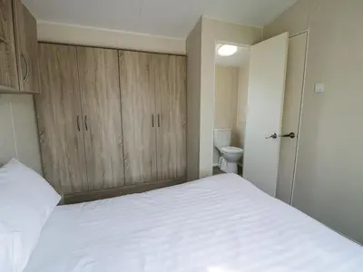 a bedroom with a white bed and a toilet at Manor House Gold 2 Bedroom 20C in Maryport
