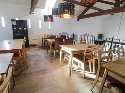 a dining room with wooden tables and chairs at Manor House Gold 2 Bedroom 20C in Maryport
