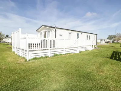 a white house with a fence in a yard at Manor House Platinum 3 Bedroom 16E in Maryport