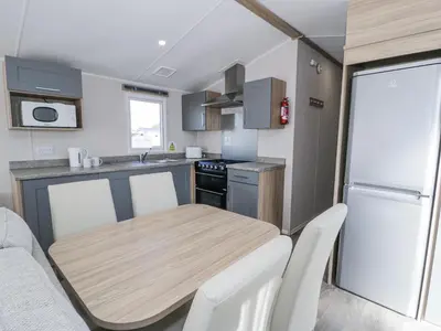 a small kitchen with a wooden table in a caravan at Manor House Platinum 3 Bedroom 16E in Maryport