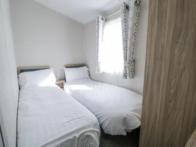 two beds in a small room with a window at Manor House Platinum 3 Bedroom 16E in Maryport