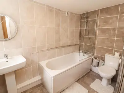 a bathroom with a tub and a toilet and a sink at Sun House in Maryport