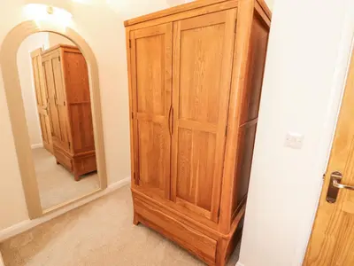 a wooden cabinet in a room with a mirror at Sun House in Maryport