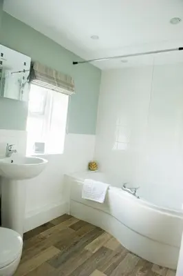 a white bathroom with a tub and a sink at Charming cosy Lakeland cottage near Ullswater in Dacre