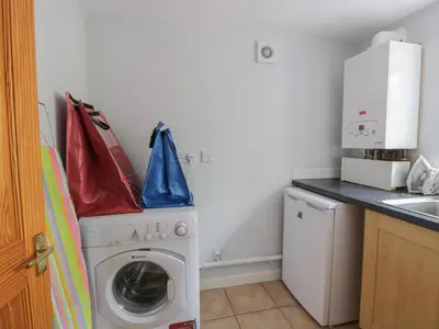 a washing machine with bags on top of it at King's Apartment in Castle Douglas