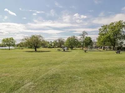 an empty park with a playground and trees at King's Apartment in Castle Douglas