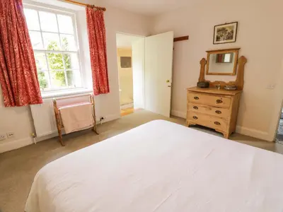 a bedroom with a white bed and a window and a dresser at Townhead of Auchenbainzie in Thornhill