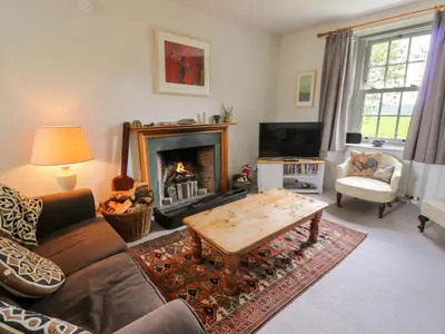 a living room with a couch and a fireplace at Townhead of Auchenbainzie in Thornhill