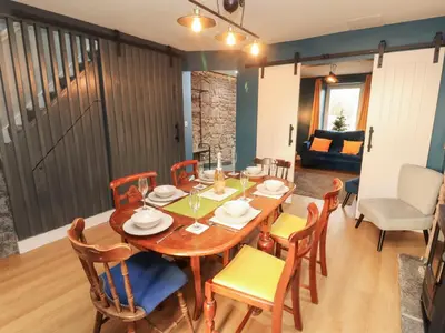 a dining room with a wooden table and chairs at 10 Keekle Terrace in Cleator Moor