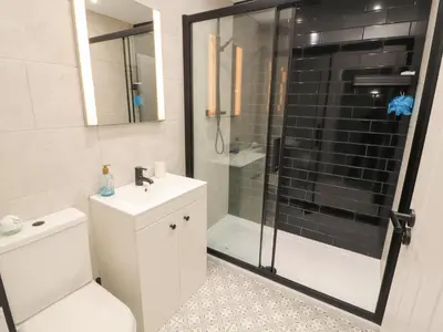 a bathroom with a shower and a toilet and a sink at 10 Keekle Terrace in Cleator Moor