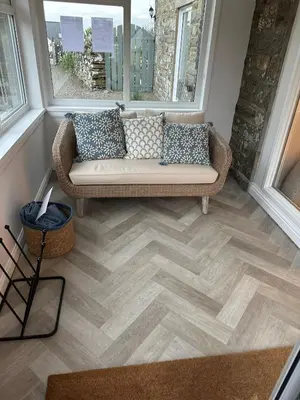 a living room with a couch and two windows at Owl Cote in Girthon