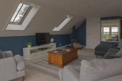 a living room with a couch and a coffee table at Owl Cote in Girthon
