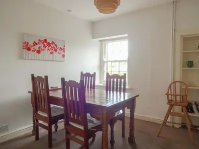a dining room with a wooden table and chairs at Emilys Apartment, Ireby with fell views, ideal budget holiday for a family in Ireby