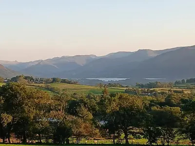 a view of a valley with mountains and a lake at Emilys Apartment, Ireby with fell views, ideal budget holiday for a family in Ireby