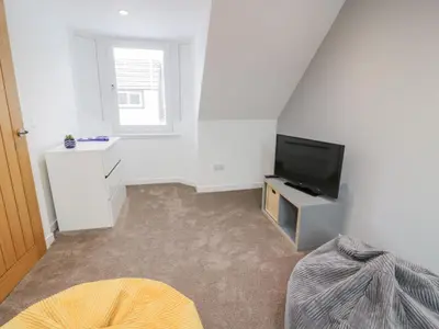 a white room with a television and a bed at Beach House in Stranraer