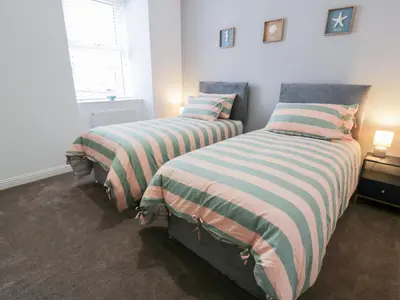 a bedroom with two beds with striped blankets at Beach House in Stranraer