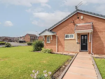 a brick house with a lawn in front of it at 3 Hawk Place in Whitehaven