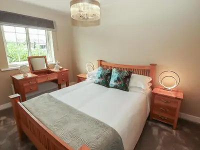 a bedroom with a bed and a window and a mirror at 3 Hawk Place in Whitehaven