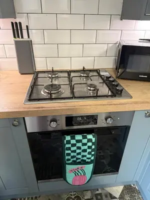 a stove top oven sitting under a counter in a kitchen at 2 bedroom cottage in Ayr