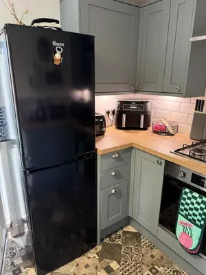 a kitchen with a black refrigerator in a kitchen at 2 bedroom cottage in Ayr