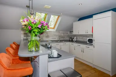 a kitchen with a vase of flowers on a counter at Hill View at Kenmuir in Dalbeattie