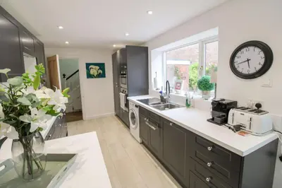a kitchen with a large clock on the wall at Chertsey Mount Townhouse, within 10 minutes walk of Carlisle city centre, shops, pubs & restaurants in Carlisle