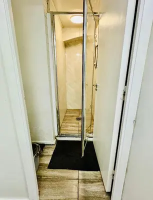 a hallway with a walk in shower in a room at Apartment in the heart of London in Moffat
