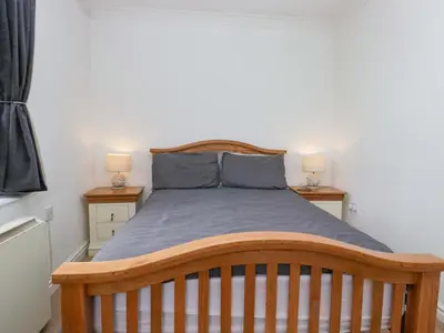 a bedroom with a wooden bed with two lamps at Duncan Square in Whitehaven