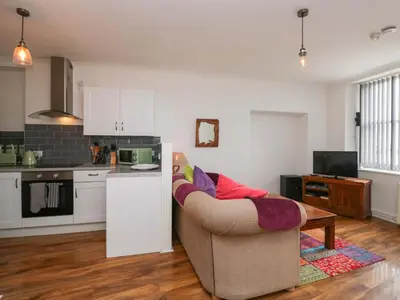 a living room with a couch and a kitchen at Duncan Square in Whitehaven
