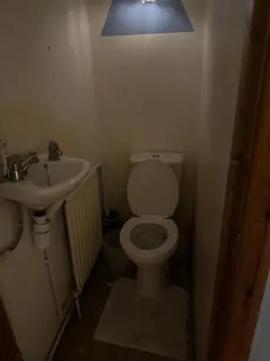 a bathroom with a toilet and a sink and a light at Home Sweet Home in Moffat
