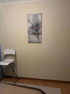 a painting on a white wall with a chair at Home Sweet Home in Moffat