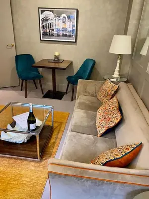 a living room with a couch and a table at Elegant Chelsea Apartment in Moffat
