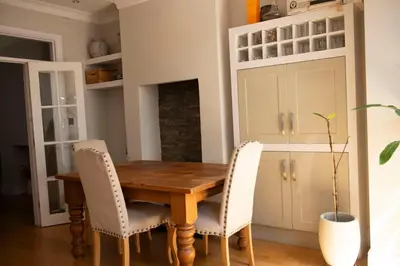 a dining room with a wooden table and chairs at Wimbledon Tennis House in Moffat
