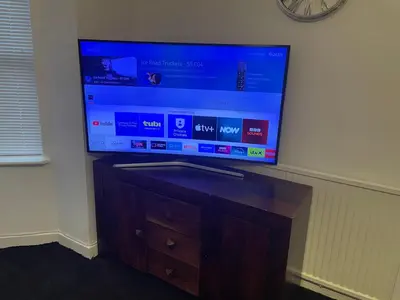 a flat screen tv sitting on top of a wooden cabinet at Home in Reading Uni Area in Moffat