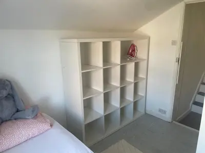 a white book shelf in a bedroom with a bed at Home in Reading Uni Area in Moffat