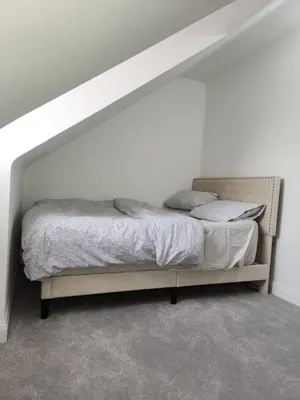 a bed in a room with a white wall at Edinburgh Road Nuneaton in Moffat